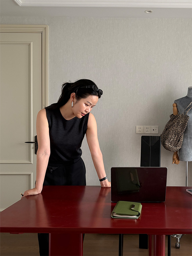 Amy, founder of Cawoolyang, in the Shanghai design studio — reviewing collections at her desk